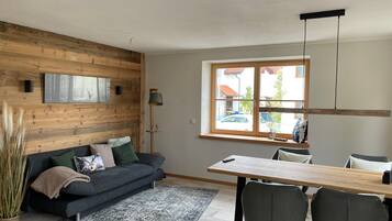 Een moderne woonkamer met een bank, een eettafel en stoelen.