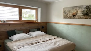 Un dormitorio con cama, ventana y un cuadro en la pared.