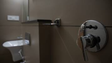 A bathroom with a modern faucet and a mirror.