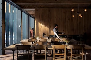 Un restaurant avec des meubles en bois et un serveur.