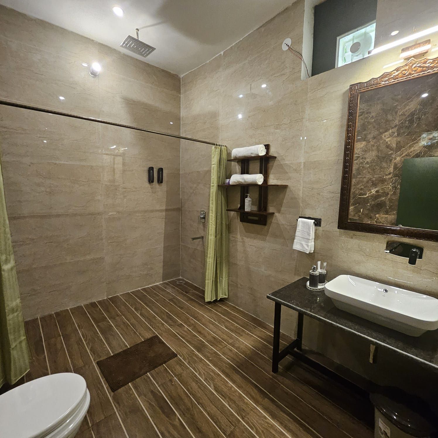 Een moderne badkamer met een douche, toilet en wastafel.