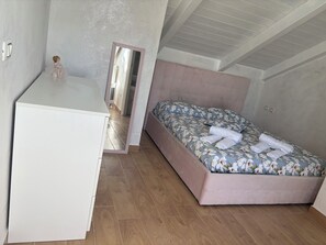 Ein Schlafzimmer mit einem Bett, einem Schreibtisch und einer kleinen Kommode.