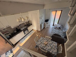 Ein kompakter Wohnbereich mit Küchenzeile, Essbereich und einer Couch.