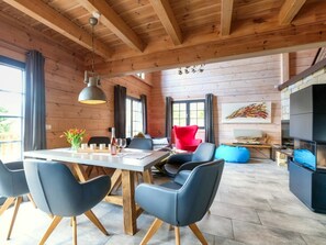 A modern interior with a dining area, seating, and a fireplace. - Holiday Home in Schierke With Sauna (Wernigerode)