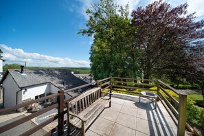 A wooden staircase leading to a terrace with a view of a white building and a tree. - Courtyard Cottage, Barnstaple (Barnstaple)