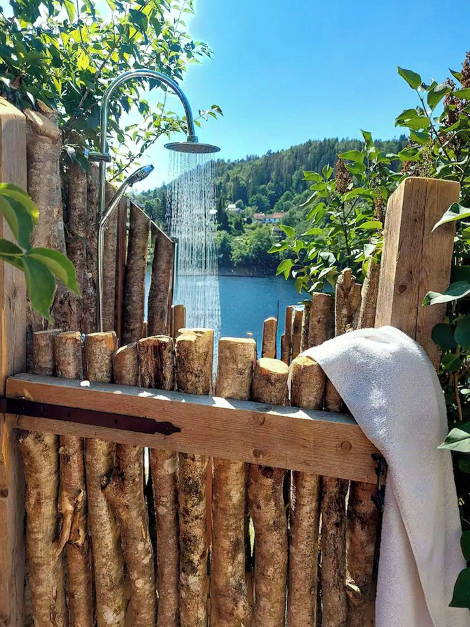 Un banco de madera con una toalla, con vista a un lago y una cascada.
