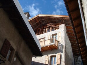 A building with a wooden balcony and a stone facade. - A historic house in a small mountain village near the Adamello-Brenta Nature Park. (Ragoli - Tre Ville)