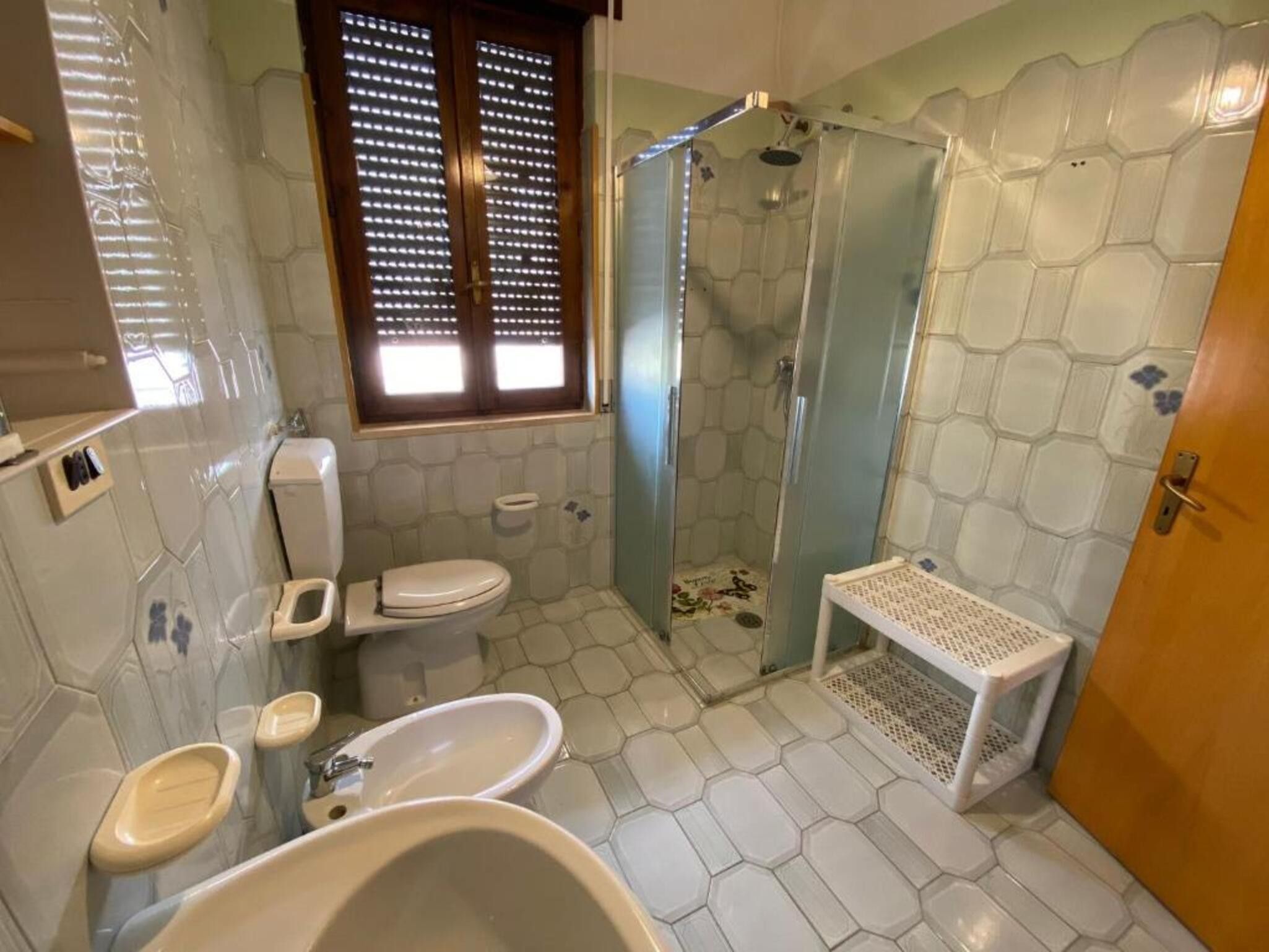 Ein Badezimmer mit Toilette, Waschbecken, Badewanne und Duschbereich.