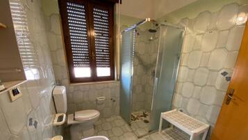Ein Badezimmer mit Toilette, Waschbecken, Badewanne und Duschbereich.