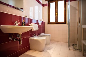 A bathroom with a sink, toilet, bidet, and a glass shower enclosure. - Apartment 'Residence Eriguez - 5' with Shared Pool, Wi-Fi and Air Conditioning (Marina di Mancaversa)