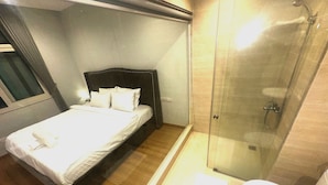 Hotellihuone, jossa on sänky, suihku ja wc.