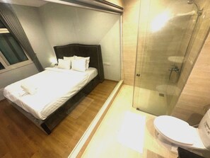Una habitación de hotel con cama, ducha y baño.