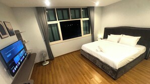Hotellihuone, jossa on sänky, televisio, työpöytä ja ikkuna.