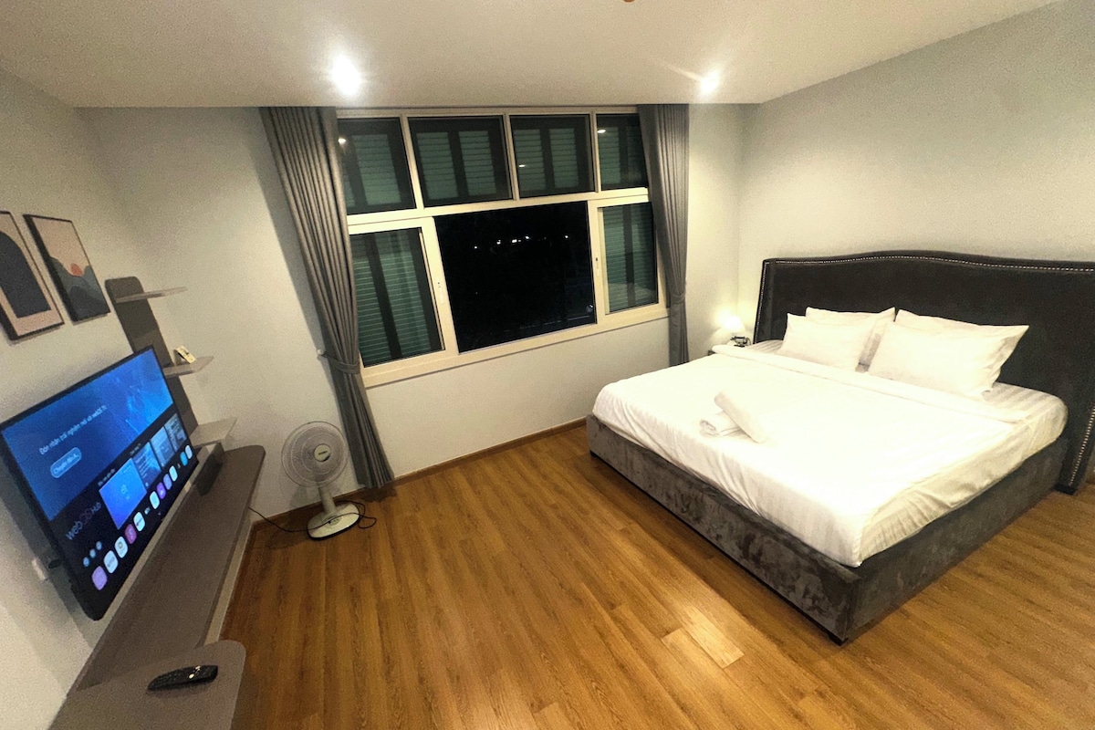 Una habitación de hotel con cama, televisión, escritorio y ventana.