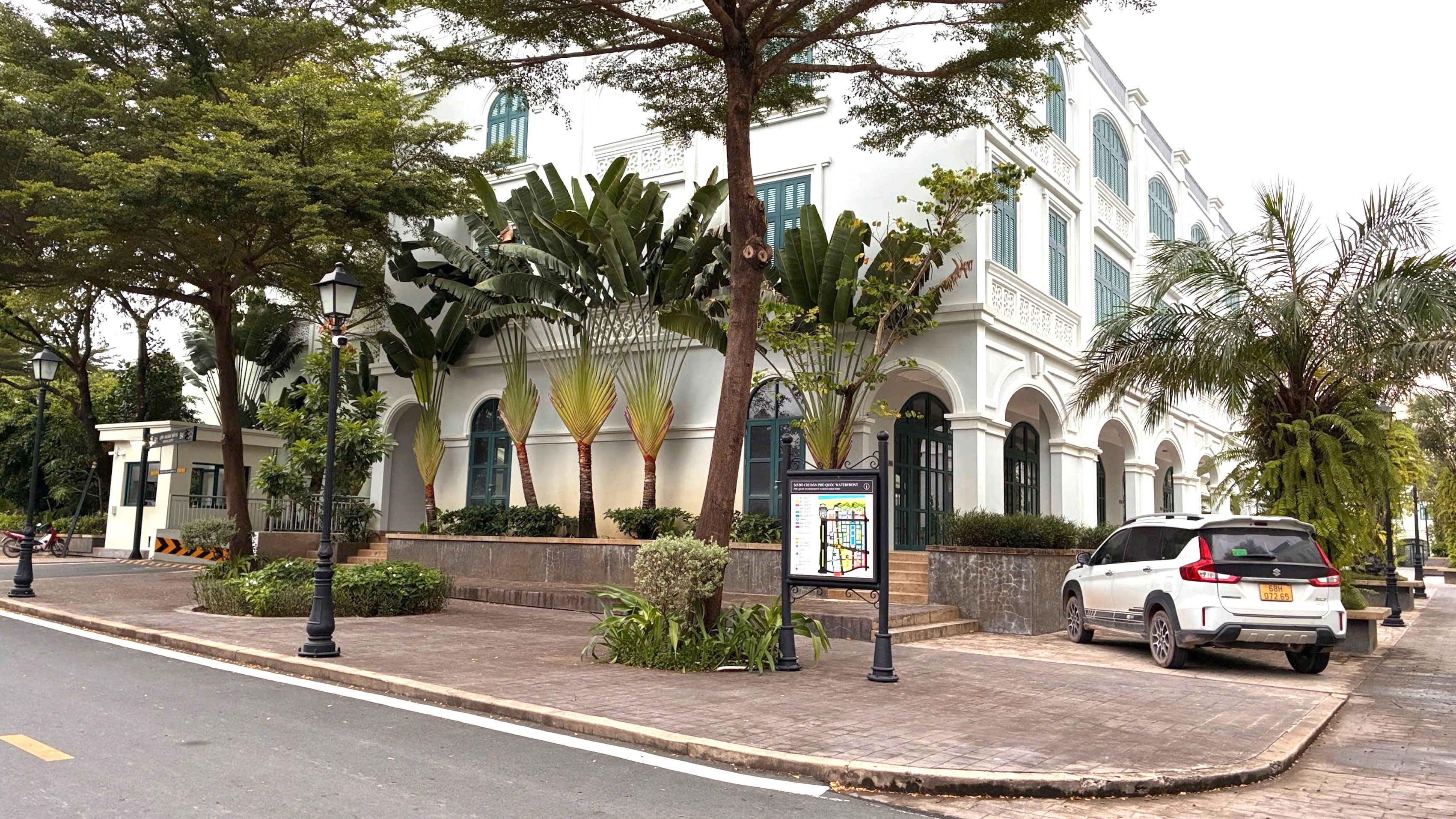 Un edificio blanco con ventanas de arco y un cartel.