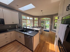 Una cocina moderna con tragaluces, armarios de madera y vistas al exterior.