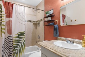 Ein Badezimmer mit Dusche, Badewanne, Waschbecken und Spiegel.
