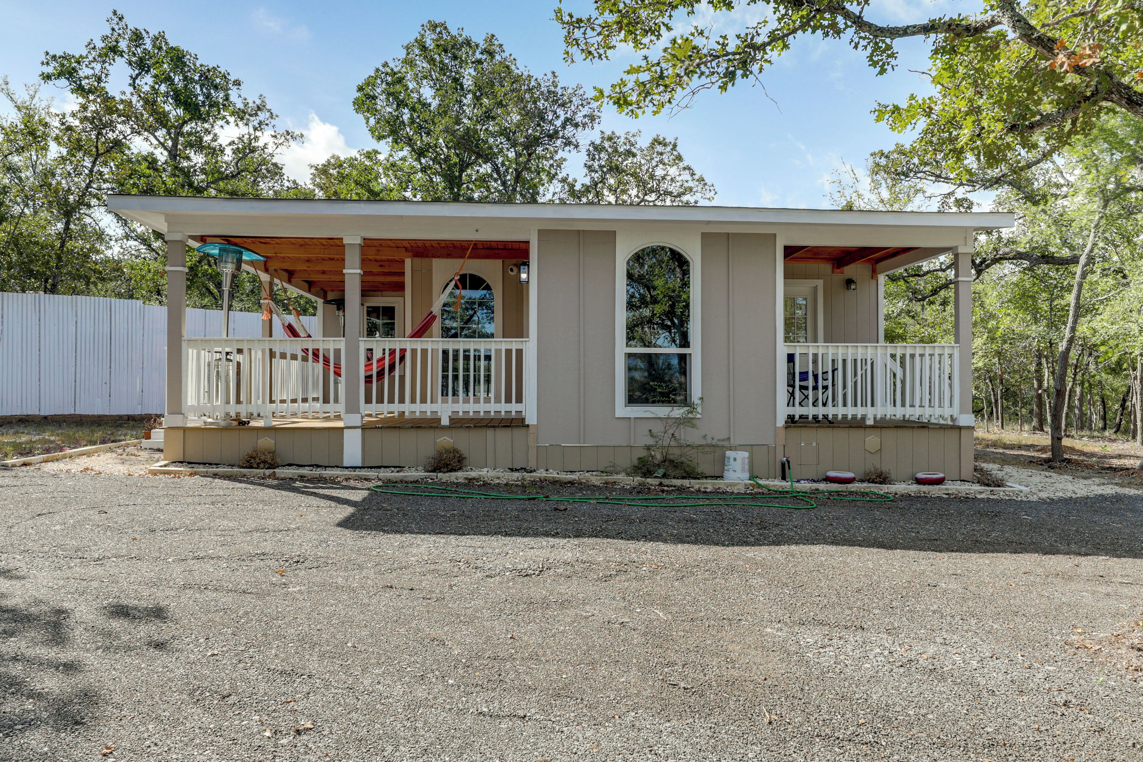 A single-story house with a porch, a swing, and a hammock.