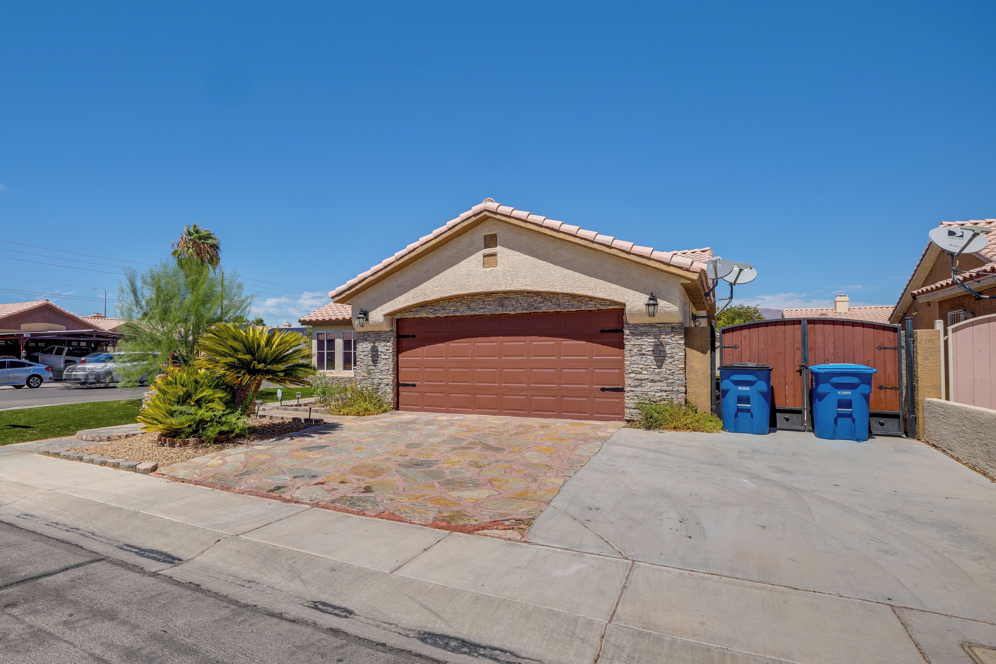 A residential property with a garage, stone facade, and satellite dish.