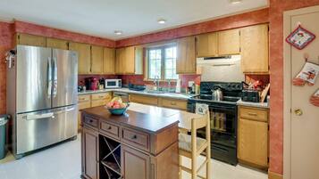 A modern kitchen with stainless steel appliances, wooden cabinets, and a central island.