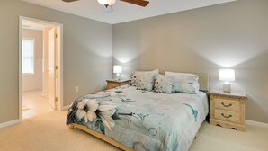 A bedroom with a bed, nightstands, a ceiling fan, and a door leading to another room. - Private Yard: Fire Pit & Cornhole! Moorefield Gem (Moorefield)