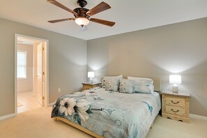 A bedroom with a bed, nightstands, a ceiling fan, and a door leading to another room. - Private Yard: Fire Pit & Cornhole! Moorefield Gem (Moorefield)