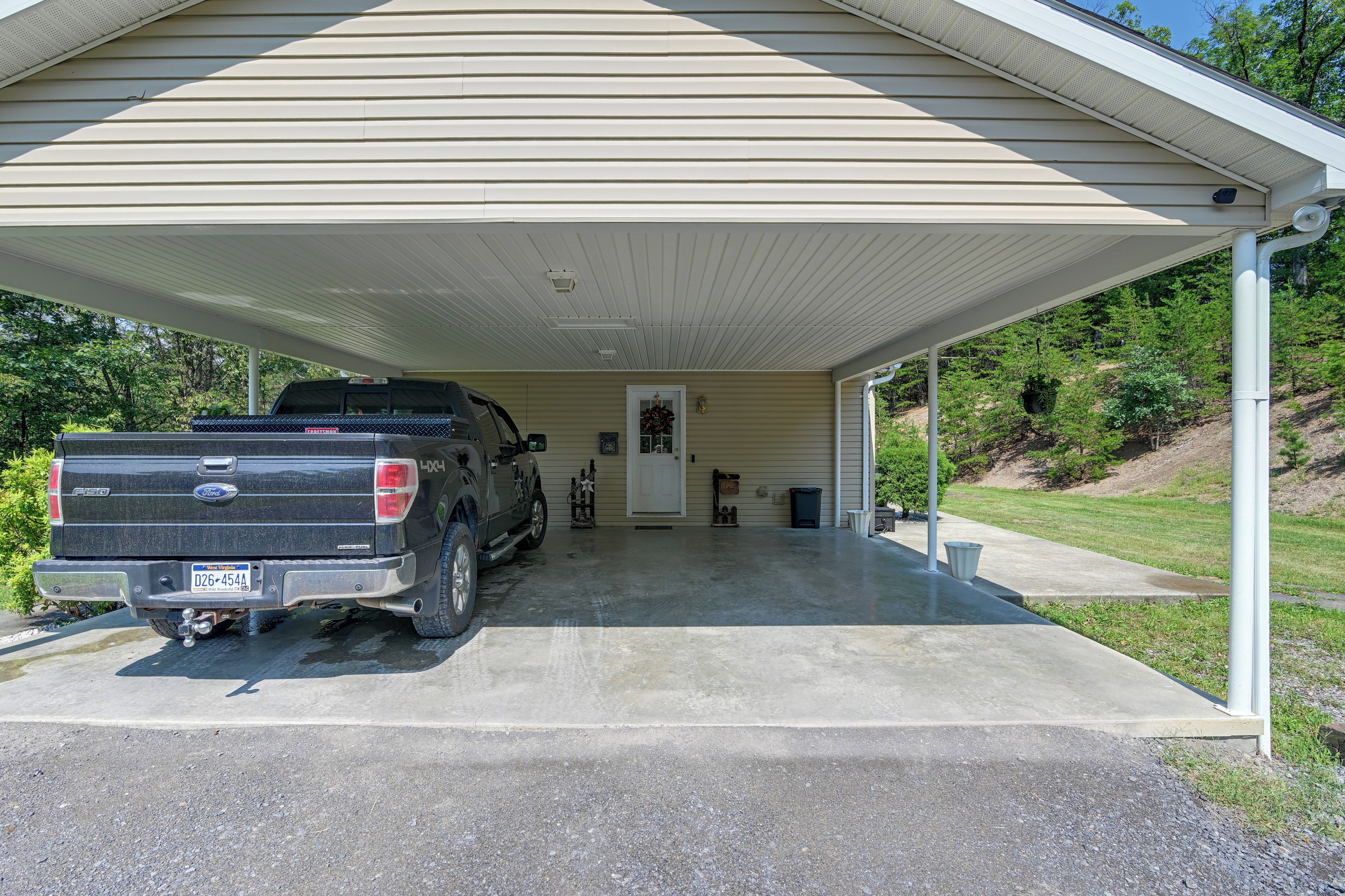 A covered garage with a black pickup truck parked inside.