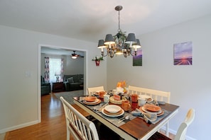 A dining area with a wooden table set for a meal, a chandelier, and a painting on the wall. - Private Yard: Fire Pit & Cornhole! Moorefield Gem (Moorefield)
