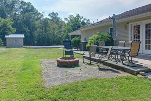 A backyard with a fire pit, outdoor furniture, and a house with a satellite dish. - Private Yard: Fire Pit & Cornhole! Moorefield Gem (Moorefield)