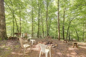 A forested area with picnic tables and chairs. - Wolf Pen Gap Getaway in 3 Cabins, Sleeps 32! (Mena)