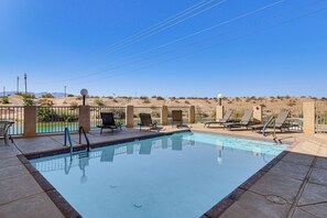 A swimming pool with lounge chairs and a view of a desert landscape. - Waterfront Escape! Lake Havasu Condo w/ Pool (Lake Havasu City)