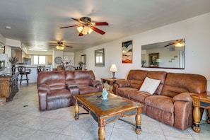 A spacious living room with leather sofas, a wooden coffee table, and a ceiling fan. - Waterfront Escape! Lake Havasu Condo w/ Pool (Lake Havasu City)