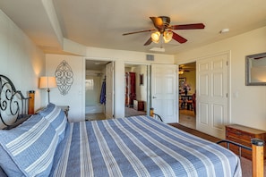 A bedroom with a bed, a ceiling fan, a nightstand, a dresser, and a door leading to another room. - Waterfront Escape! Lake Havasu Condo w/ Pool (Lake Havasu City)