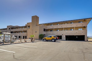 A multi-story building with a parking lot and a yellow vehicle parked in front. - Waterfront Escape! Lake Havasu Condo w/ Pool (Lake Havasu City)