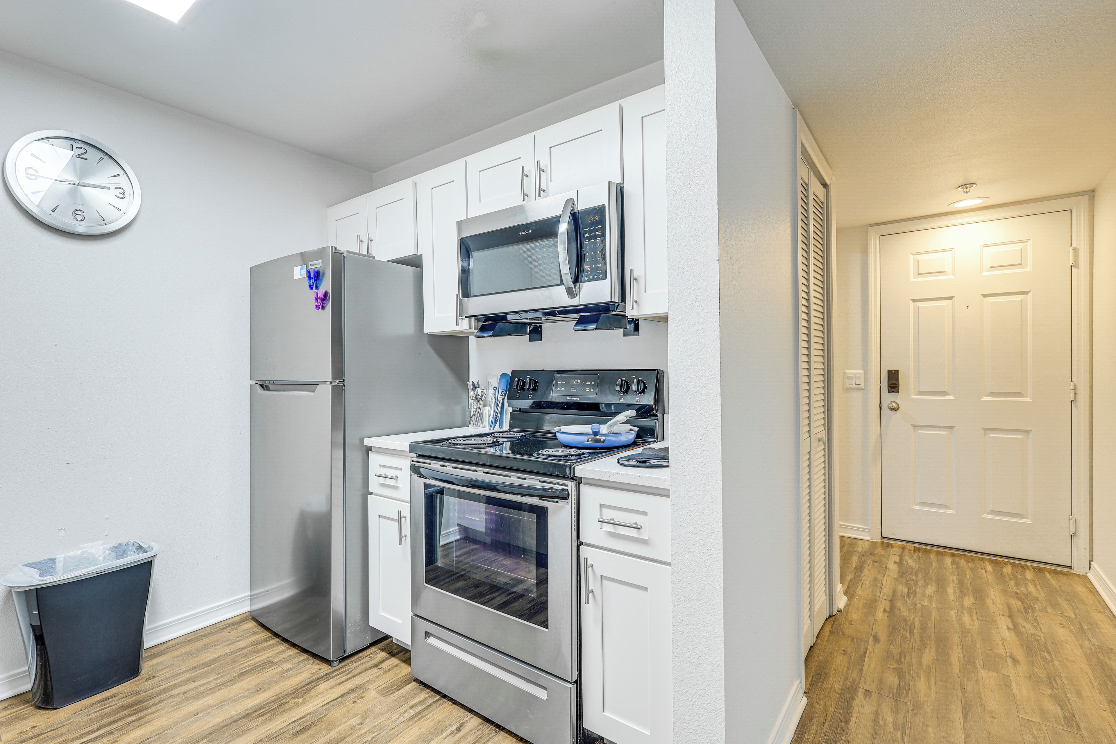 A compact kitchen with a refrigerator, microwave, stove, and oven.
