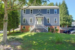 A two-story house with a front porch, a brick foundation, and a well-maintained lawn. - Stylish & Spacious Home w/ Fenced Yard in Richmond (Richmond)
