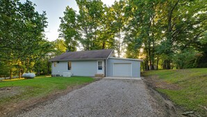 A single-story house with a gravel driveway and a small front yard. - Fall Foliage & Hot Tub Nights: Shawnee Cabin (Elizabethtown)