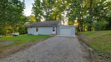 A single-story house with a gravel driveway and a small front yard.