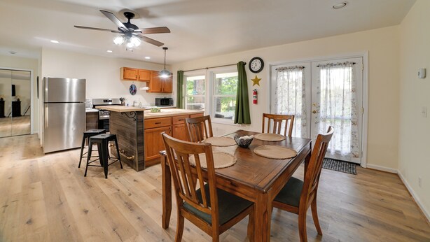 A modern kitchen with a central island, wooden chairs, and a dining table. - Fall Foliage & Hot Tub Nights: Shawnee Cabin (Elizabethtown)