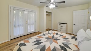 A bedroom with a ceiling fan, a bed with white bedding, a wooden floor, and a patterned rug. - Fall Foliage & Hot Tub Nights: Shawnee Cabin (Elizabethtown)