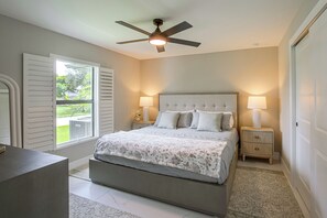 A bedroom with a bed, bedside lamps, a ceiling fan, and a window with blinds. - Brand-new Luxury Home w/ Pool! 9 Mi to Pine Island (Cape Coral)