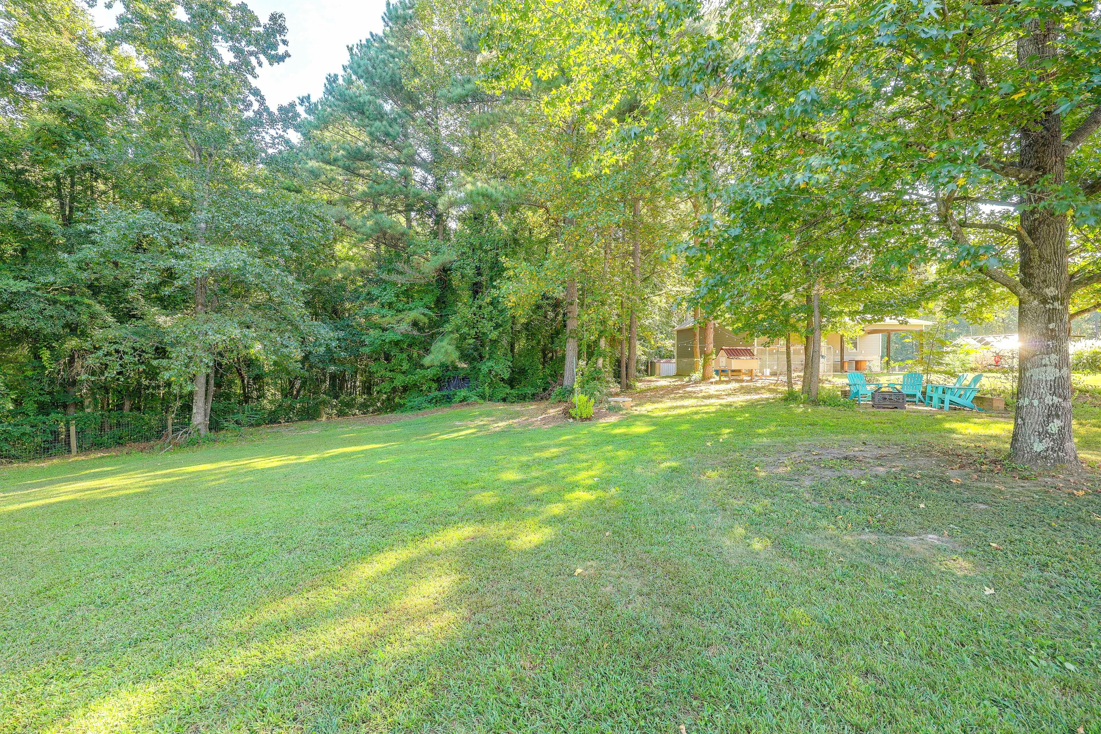 A well-maintained grassy area with trees, a fenced area, and outdoor seating.