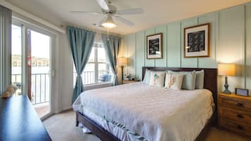 A bedroom with a bed, a nightstand, a lamp, a ceiling fan, and a window with curtains.