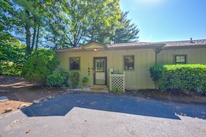 A single-story building with a front door, a small porch, and a mailbox.