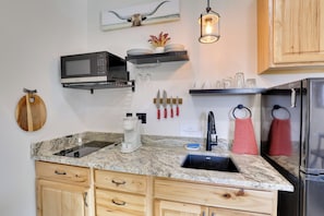 A kitchen with a built-in microwave, coffee maker, and sink. There are wooden cabinets, a hanging knife set, and a hanging towel. - Trail Access & Views! 90-acre Haven in Hot Springs (Hot Springs)