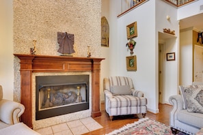 A living room with a fireplace, a striped armchair, and a sofa. - Luxury, 2 Master Suites, Fire Pit, Kayaks (Milledgeville)