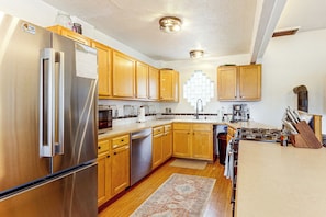 A kitchen with wooden cabinets, stainless steel appliances, a built-in oven, and a gas stove. - Deck & Views! Family Retreat Near Rmnp (Grand Lake)