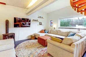 A living room with a sofa, a television, a fireplace, and a window with a view. - Deck & Views! Family Retreat Near Rmnp (Grand Lake)