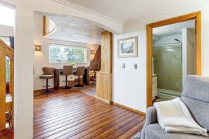 A room with a wooden floor, a grey sofa, a wooden door, and a shower area. - Deck & Views! Family Retreat Near Rmnp (Grand Lake)