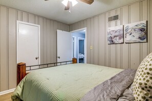 A bedroom with a bed, a ceiling fan, and two doors. - 4 Mi to Graceland! Cozy Home w/ Patio & Yard (Memphis)